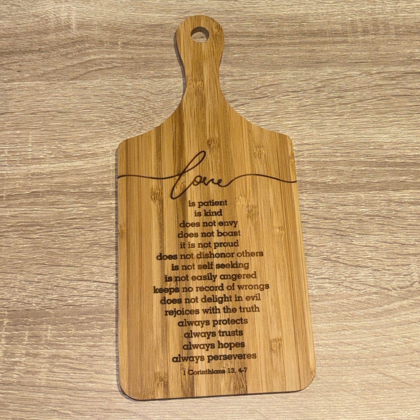 Wooden cutting board with engraved text on a wooden surface