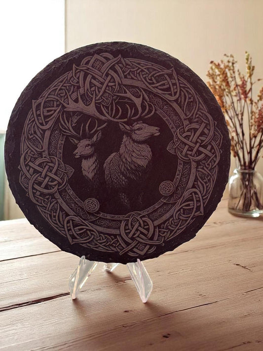 Decorative plate with Celtic knot design and deer illustration on a stand.