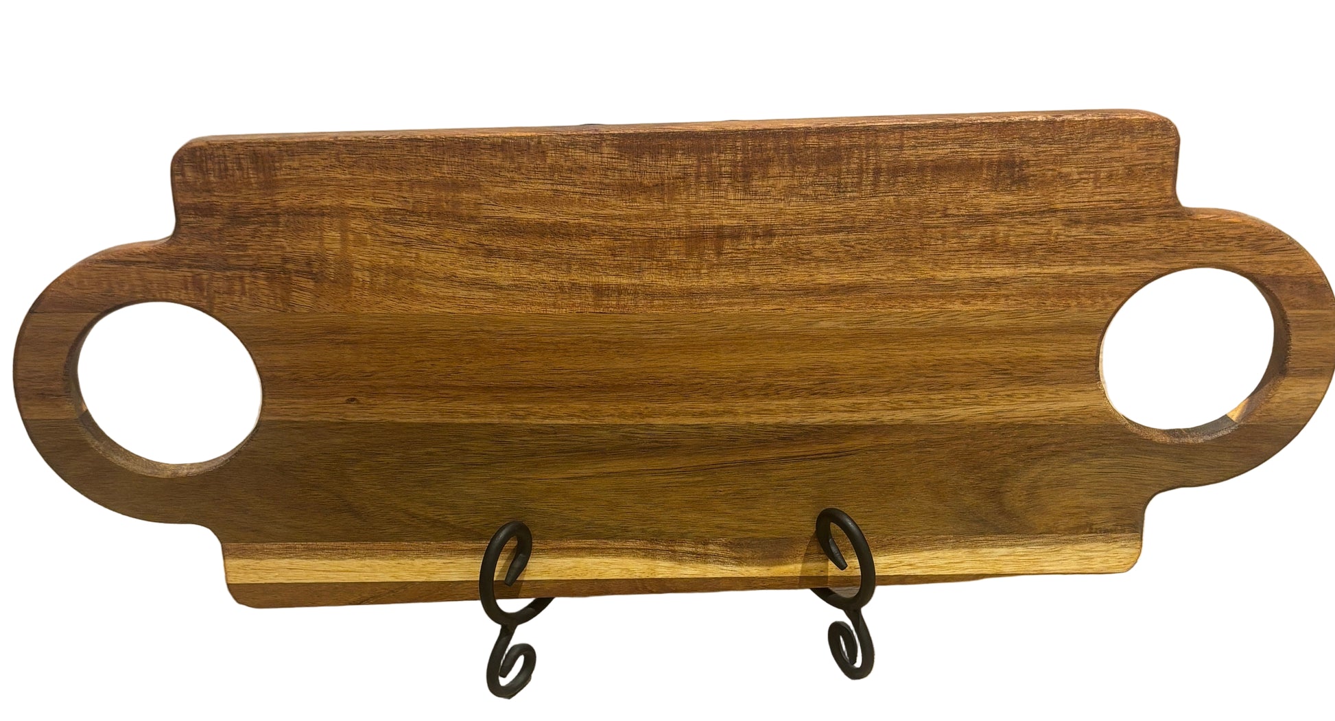 Wooden serving board with handles on a stand against a wooden background