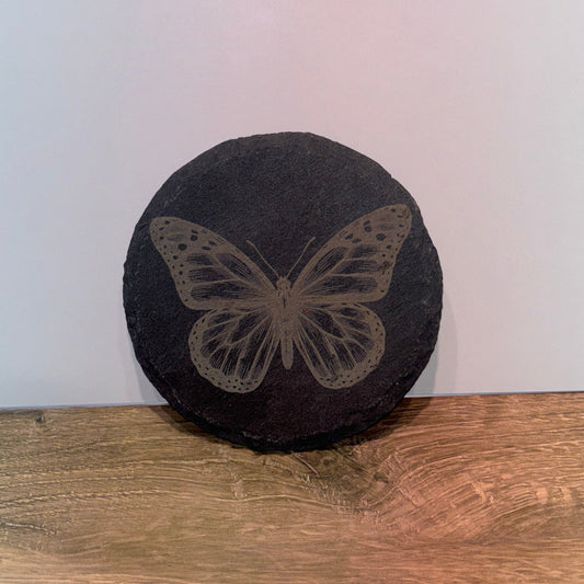 Round 4 inch black slate coaster engraved with a detailed butterfly design.