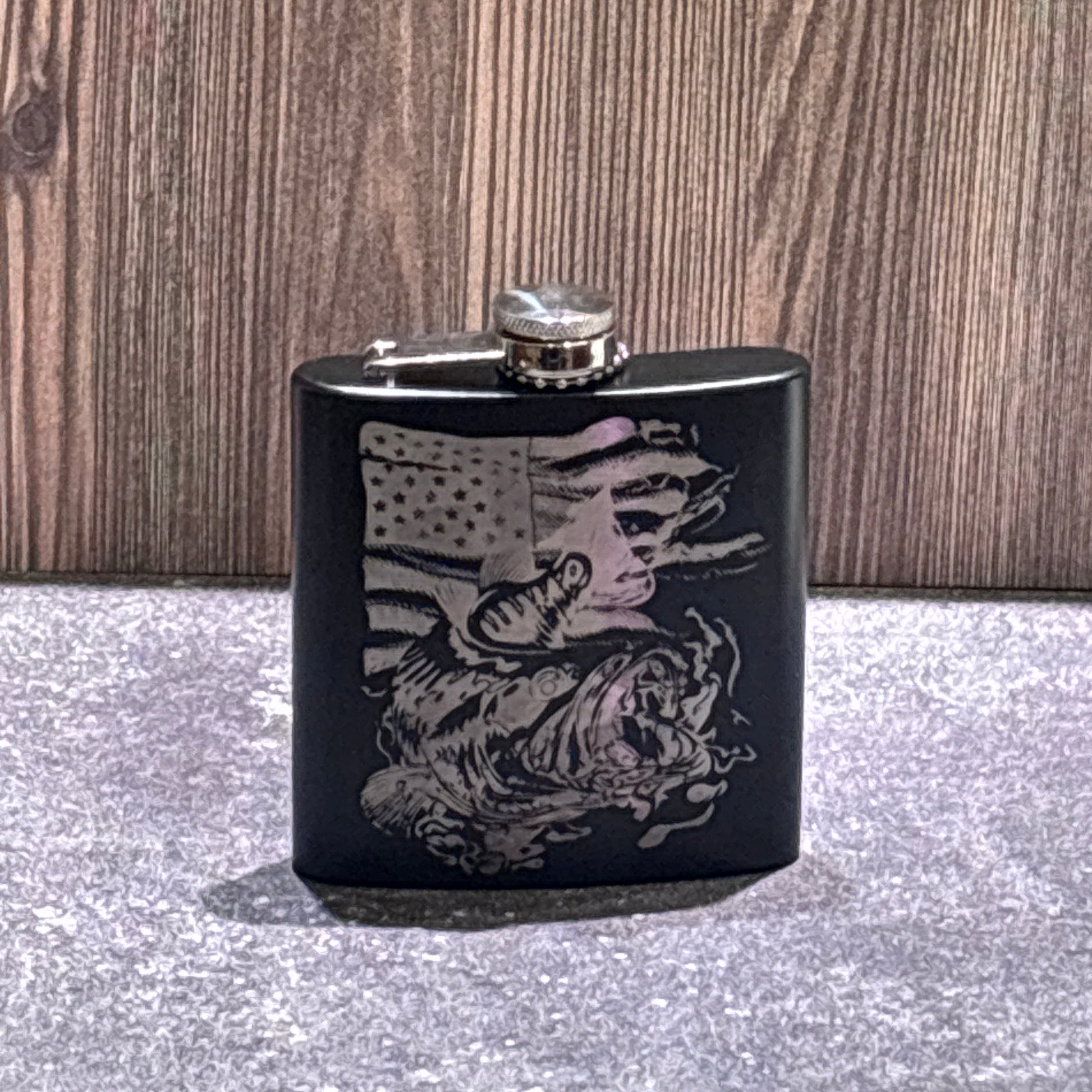 Black stainless steel flask engraved with a jumping bass fish and American flag design.
