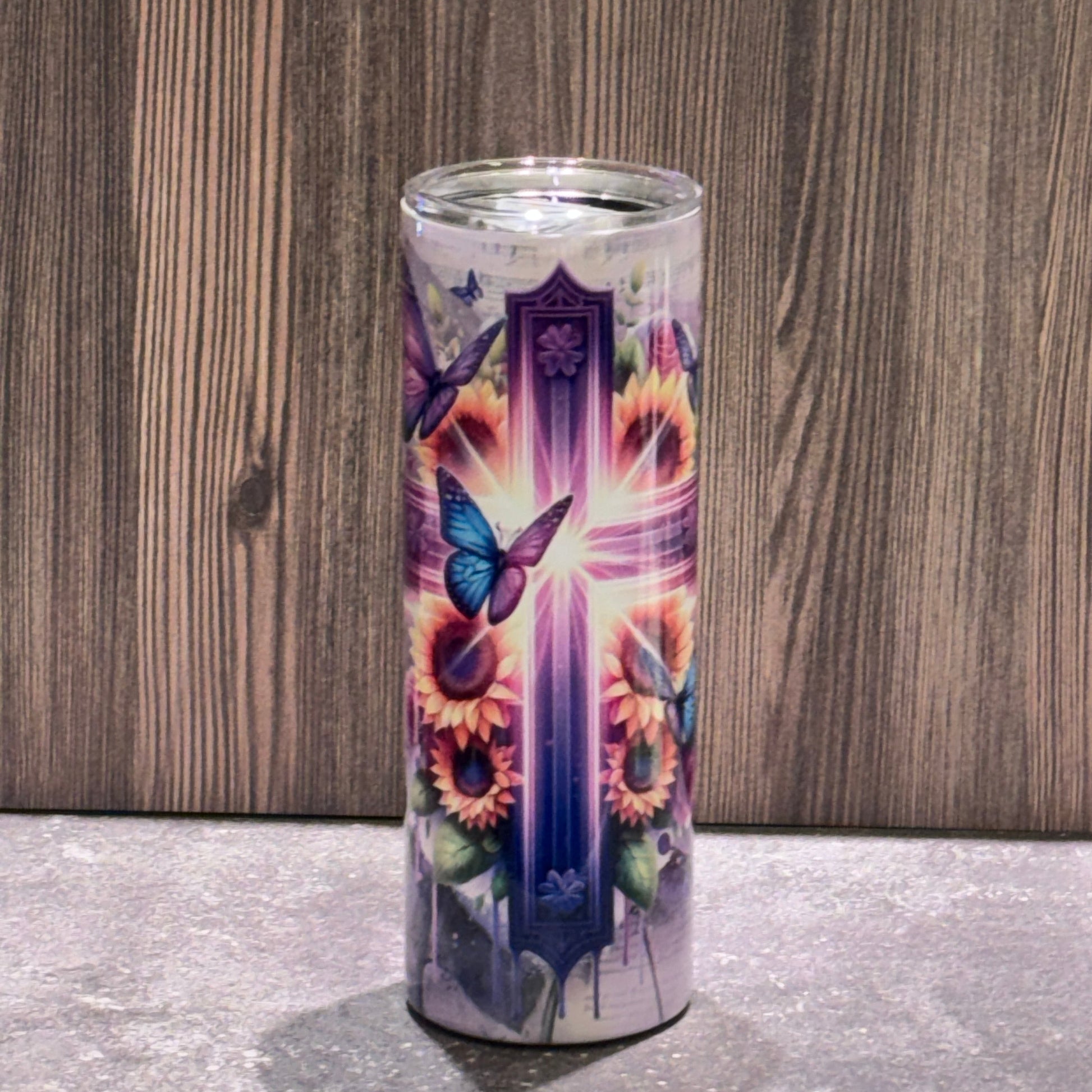 20 oz stainless steel skinny tumbler featuring a radiant Christian cross surrounded by sunflowers, butterflies, and sheet music artwork.