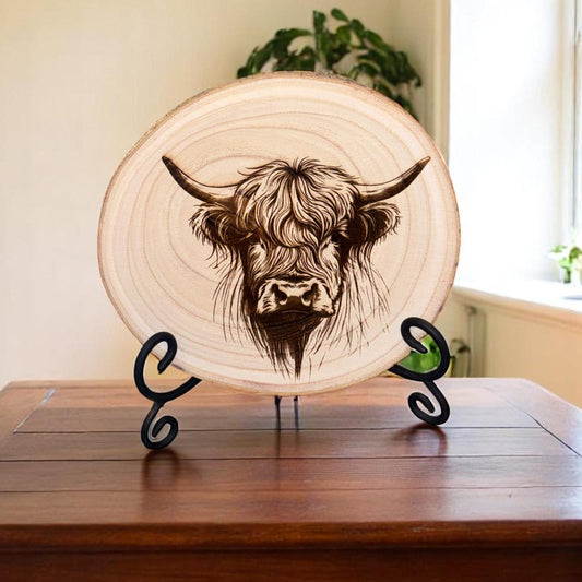 Decorative plate with a bull design on a wooden stand in a room with a window and plant.