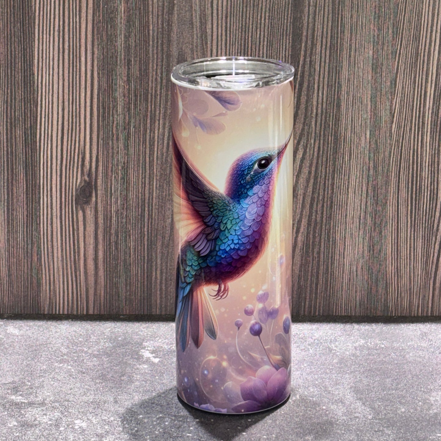 20 oz stainless steel skinny tumbler featuring a colorful hummingbird surrounded by soft floral and nature-inspired artwork.