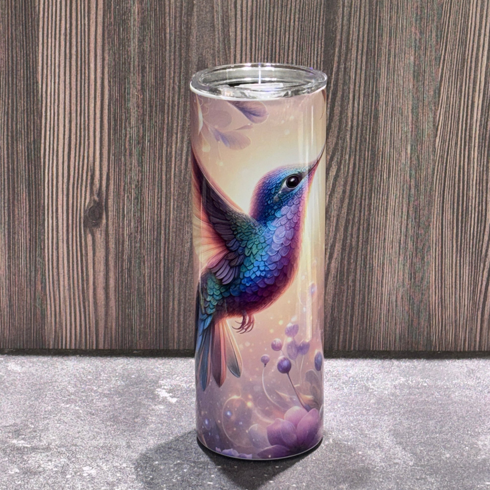 20 oz stainless steel skinny tumbler featuring a colorful hummingbird surrounded by soft floral and nature-inspired artwork.