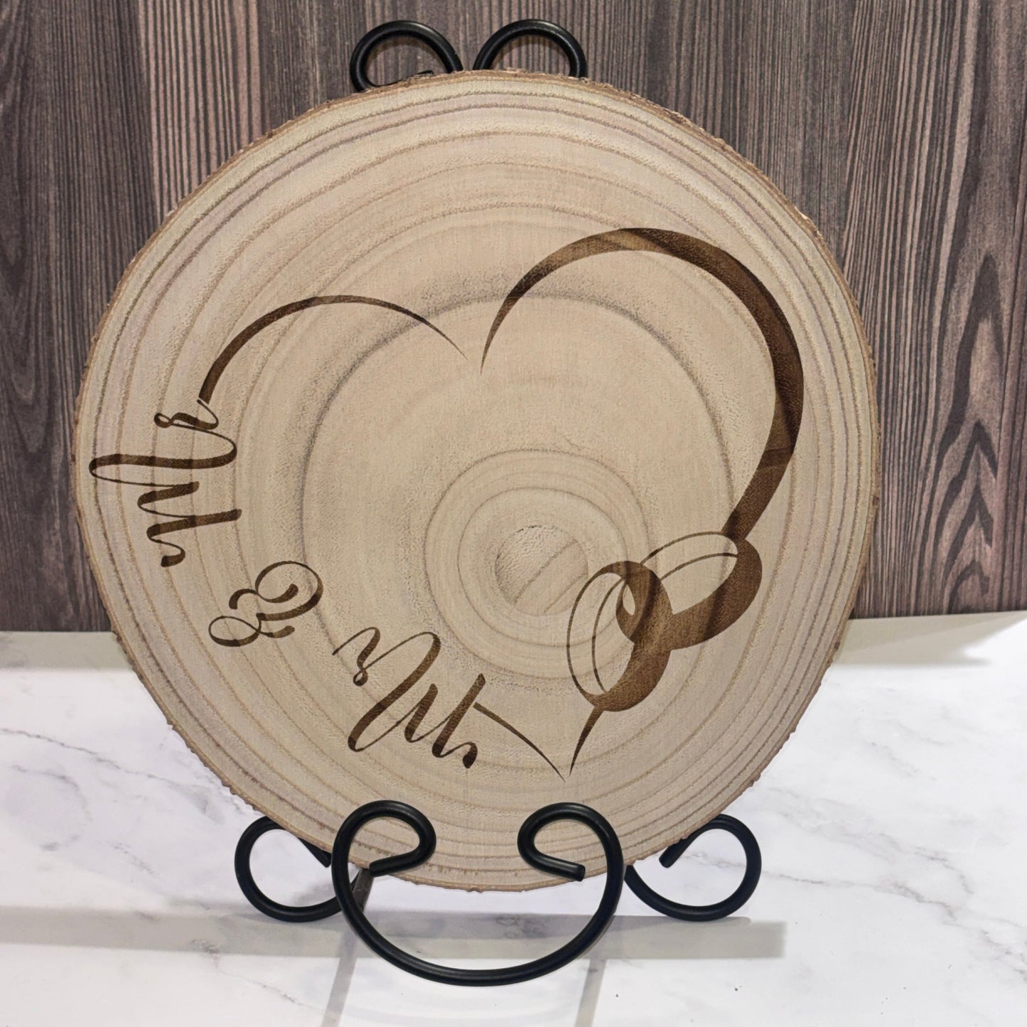 Natural 8 to 9 inch wood slice engraved with a heart design and Mr. & Mr. lettering. Stand not included.