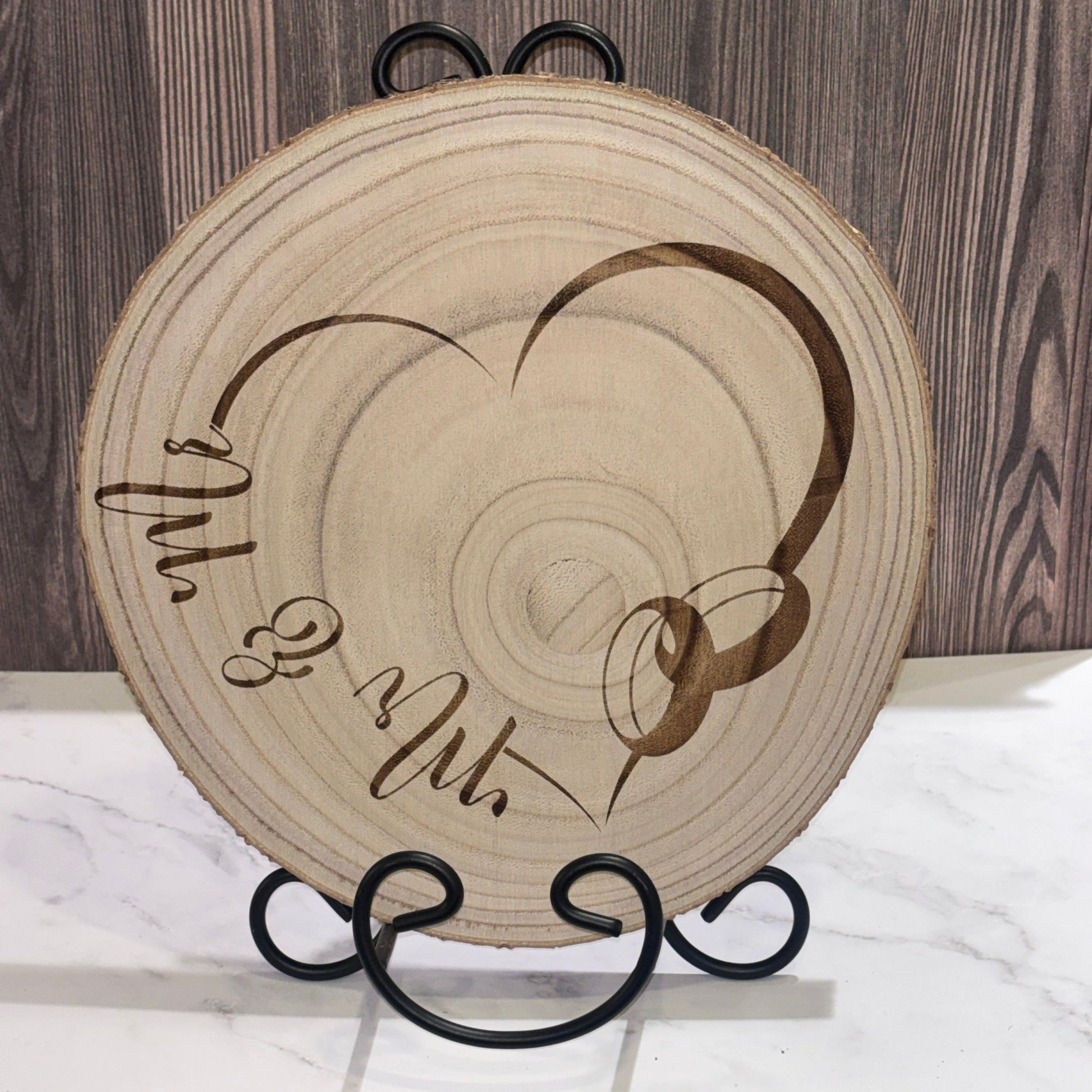 Natural 8 to 9 inch wood slice engraved with a heart design and Mr. & Mr. lettering. Stand not included.