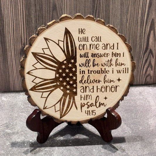 Natural 8 to 9 inch wood slice engraved with a patriotic sunflower featuring an American flag design and Psalm 91:15 scripture. Stand not included.